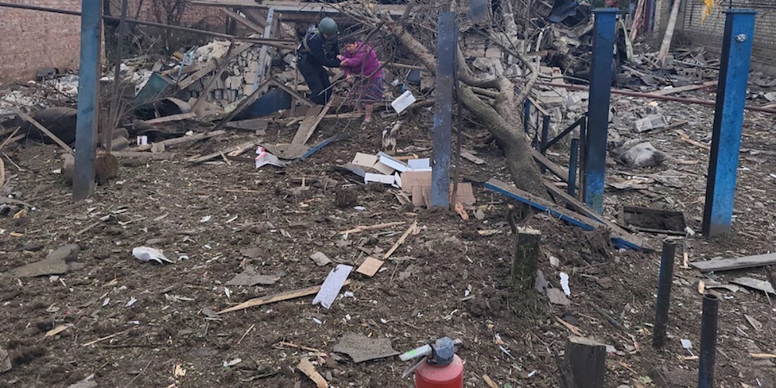 Un rescatista ayuda a una residente tras un ataque en Donbás, ayer.