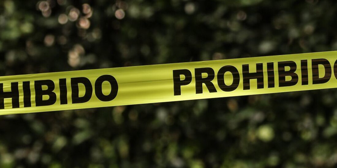 En la imagen ilustrativa se muestra una cinta amarilla con la palabra "prohibido", acordonando el área donde presumiblemente se cometió un delito