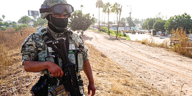Un agente de la Guardia Nacional resguarda la escena de un delito en Sinaloa.