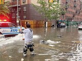 Un trabajador intenta destapar una coladera en medio de las inundaciones en Brooklyn, ayer.