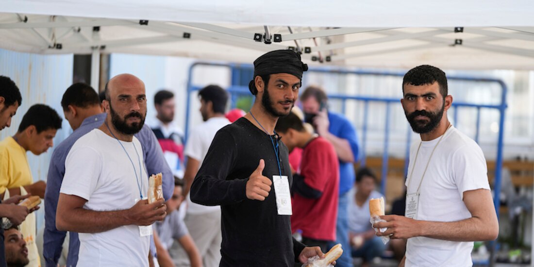 Migrantes rescatados saludan a las cámaras desde el refugio en Kalamata, ayer.