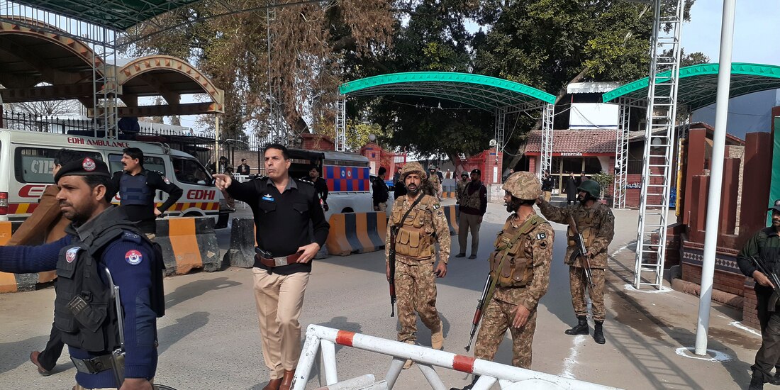 Soldados y policías despejan el acceso para ambulancias al lugar donde explotó una bomba, en una entrada a oficinas policiales en Peshawar, Pakistán, el lunes 30 de enero de 2023