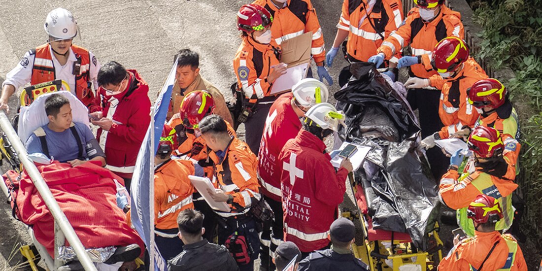 Bomberos retiran un cuerpo de la zona del siniestro en el complejo de edificios de Tai Po, ayer.