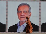 Una mujer pasa frente a un anuncio con la imagen del presidente de Irán, Masoud Pezeshkian, en Islamabad, Pakistán.