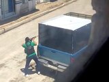 Un hombre armado se resguarda en un camión durante el enfrentamiento registrado el martes en Xoxtla.