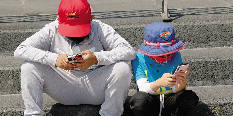 Menores se distraen con el uso del celular, en imagen de archivo.