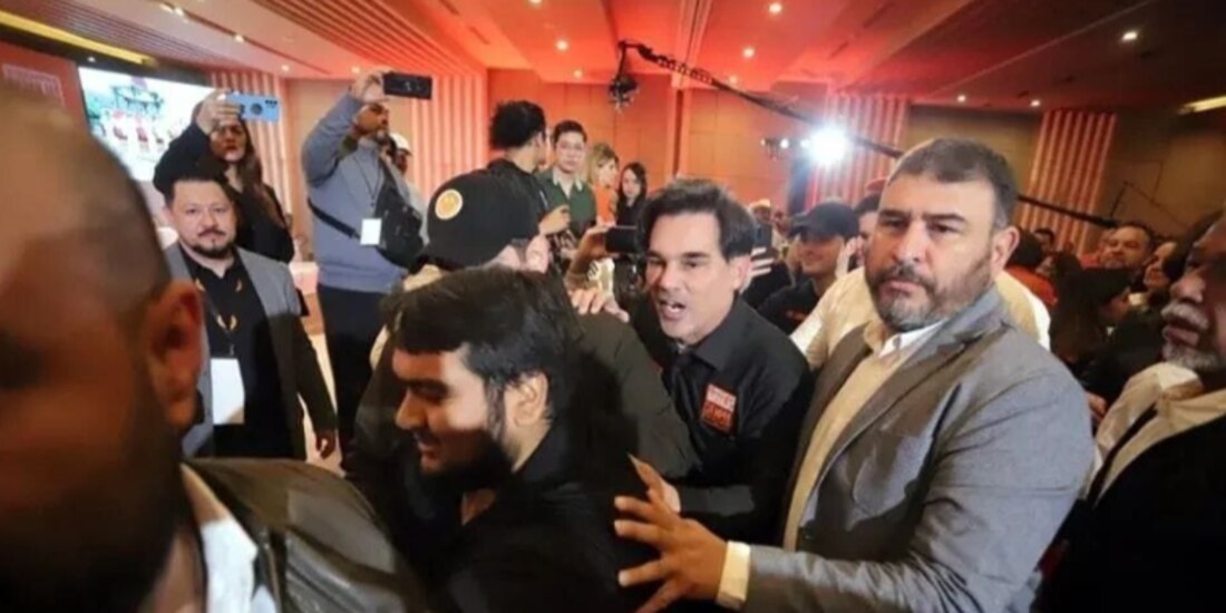 Militantes del partido tratan de sacar a manifestantes del salón en donde se llevaba a cabo el evento, ayer.