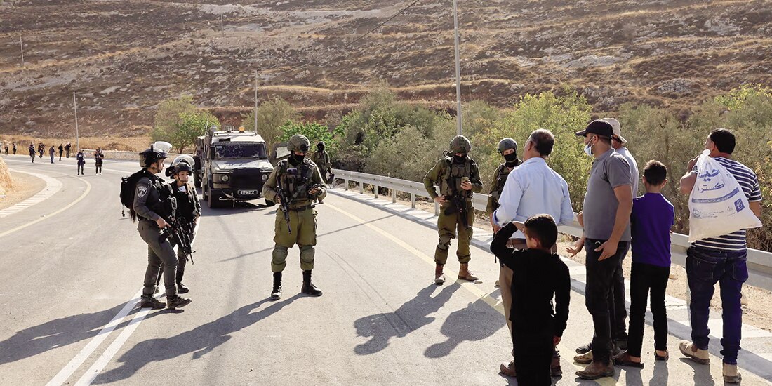 Fuerzas israelíes bloquean el acceso de palestinos y activistas extranjeros a los olivos durante la cosecha de aceitunas, en Cisjordania ocupada por Israel, ayer.