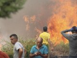Ciudadanos se alejan de un incendio forestal en Añón de Moncayo, en Zaragoza, España.