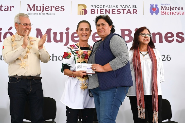 Presidenta entrega a una beneficiaria una tarjeta de la Pensión Mujeres Bienestar.
