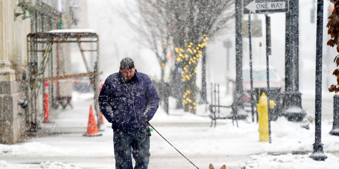 Una persona camina con su perro en una calle de Pittsfield, Massachusetts, el viernes 16 de diciembre de 2022.