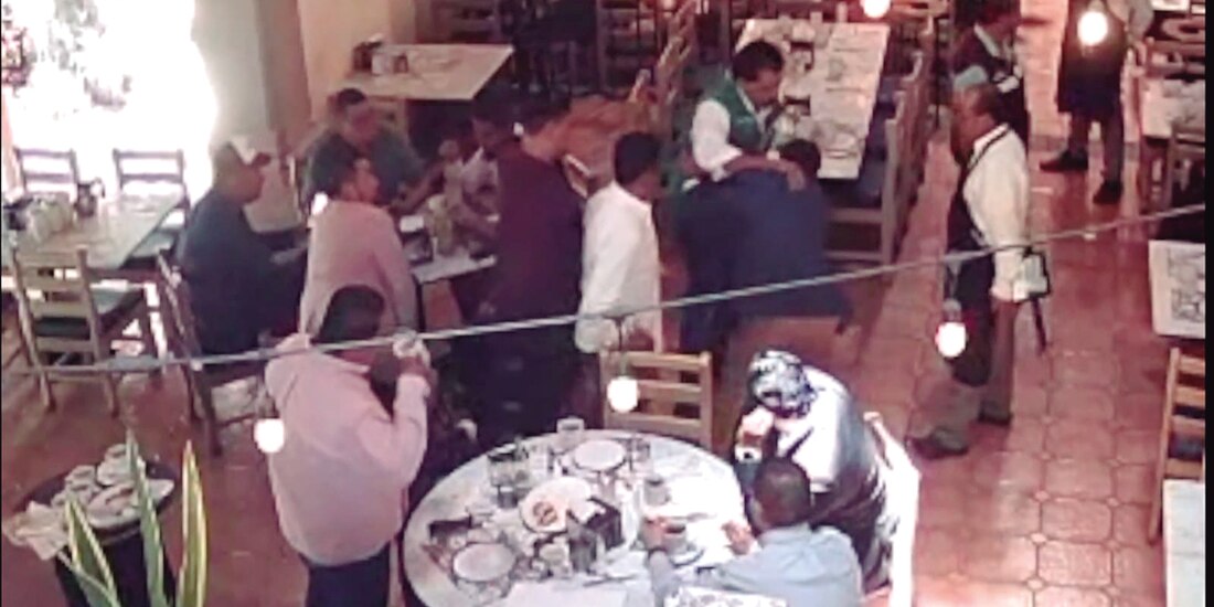 Ramón Enríquez (de chaleco verde) toma por el cuello al comunicador Heber García, el lunes.