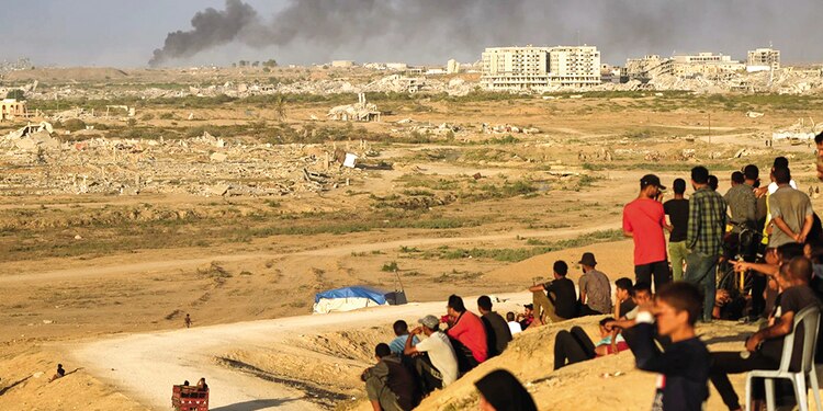Palestinos desplazados observan cómo se eleva el humo, ayer.