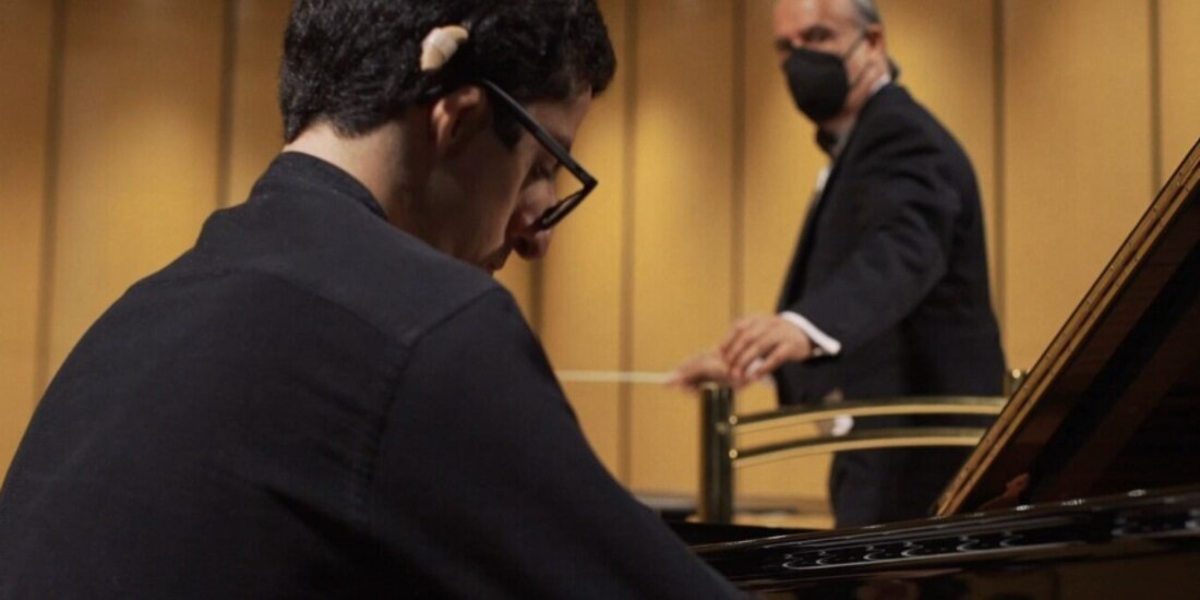 David interpreta el Concierto para Piano a 8 Dedos mientras su padre dirige a la Orquesta, en el Teatro Degollado, en Jalisco.