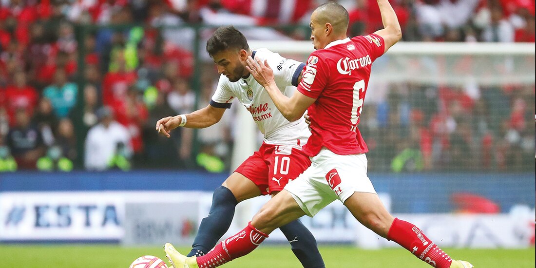 Vega y Torres Nilo pelean un balón, ayer, en el duelo que cerró la Jornada 12 del certamen mexicano.