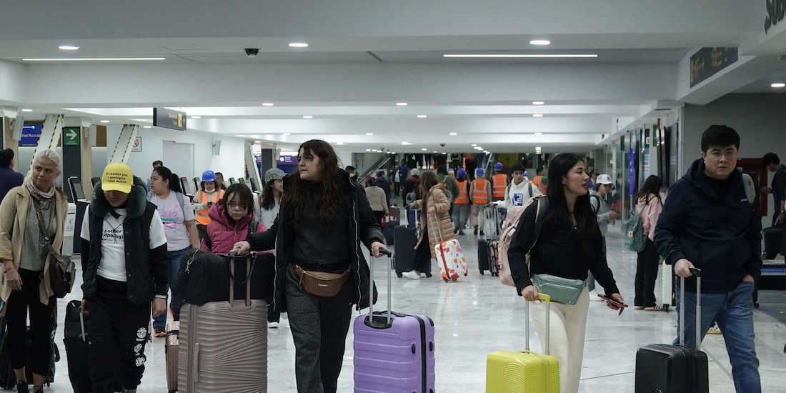 Pasajeros que llegan con sus maletas transitan por el Aeropuerto Internacional de la Ciudad de México