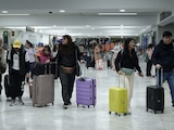 Pasajeros que llegan con sus maletas transitan por el Aeropuerto Internacional de la Ciudad de México