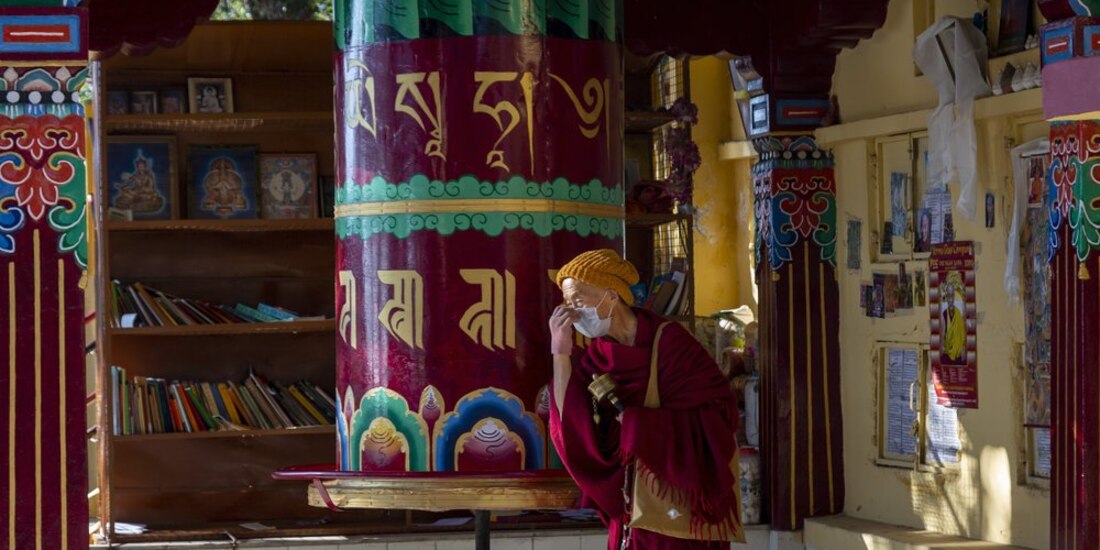 Un monje budista tibetano se protege del coronavirus con un cubrebocas.