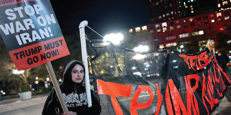 Una mujer sostiene un cartel, tras anuncio de pausa en guerra, ayer.
