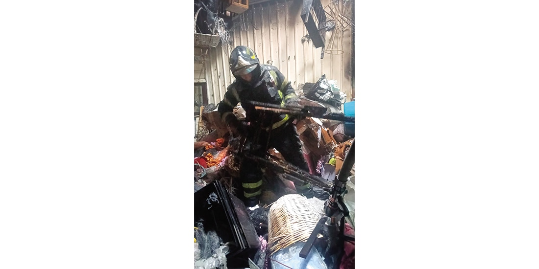 Un bombero durante las labores de enfriamiento y retiro de materiales del local del mercado afectado, ayer.