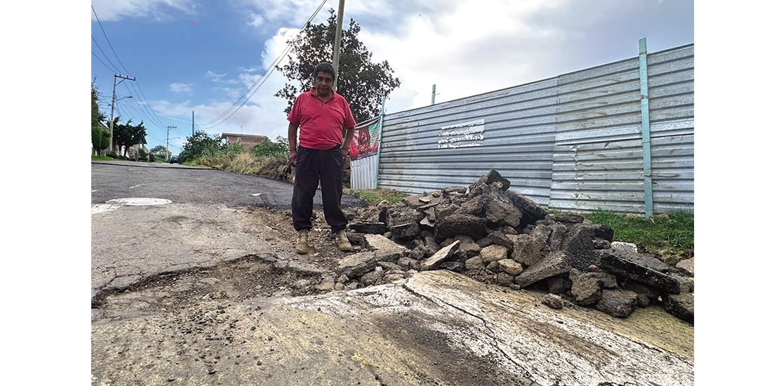 Santiago Enríquez, vecino de la calle Guadalupe Victoria, muestra un bache.