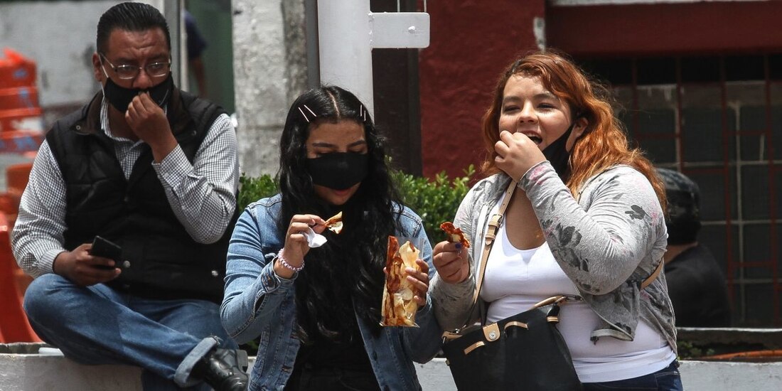 Habitantes de la Ciudad de México comen papas fritas en la calle