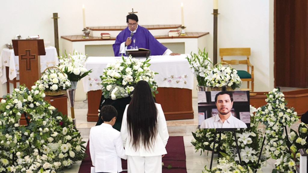 LA VIUDA y su hijo, ante el féretro del líder, el 21 de octubre.