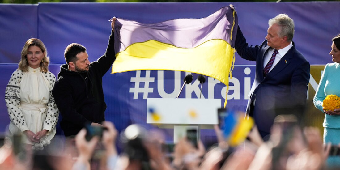 El presidente Volodimir Zelenski (izq.) sostiene una bandera ucraniana junto a su homólogo lituano, Gitanas Nauseda, previo a acudir a la cumbre de la OTAN, ayer.