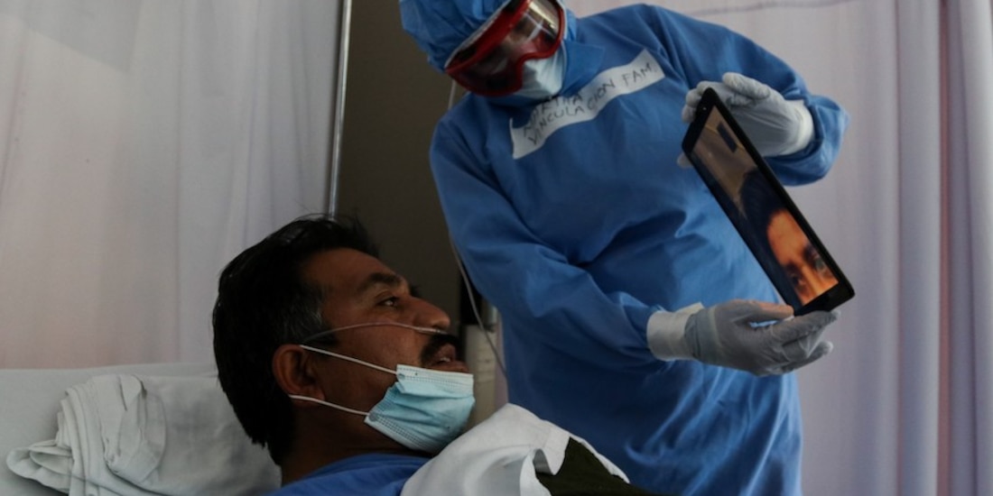 Un enfermero conecta a su paciente infectado con su familia, a través de videollamada, ayer, en CDMX.