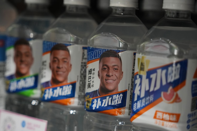 Botellas con bebidas de electrolitos de Dongpeng con la imagen del futbolista francés Kylian Mbappé en un supermercado de Beijing