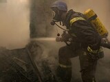 Un bombero ucraniano rocía agua dentro de una casa destruida por los bombardeos, en Kiev, Ucrania.