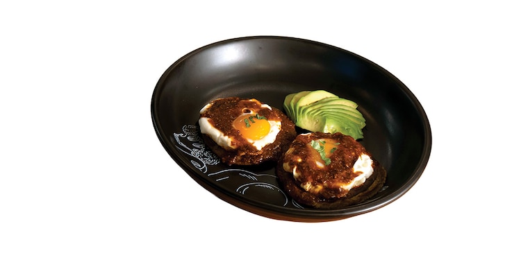Revolucionarios. Dos sopes de masa de nopal con frijoles y huevo estrellado, bañados con salsa pasilla. Aguacate como acompañante.