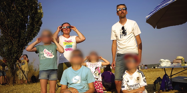 Una familia mira cómo la Luna se
interpone entre el Sol en Palencia.