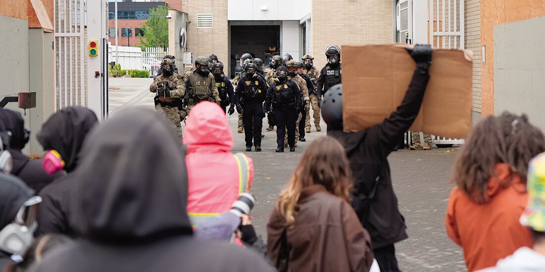 Agentes del orden regresan a una instalación del ICE, mientras gente protesta en Portland, el 11 de octubre.