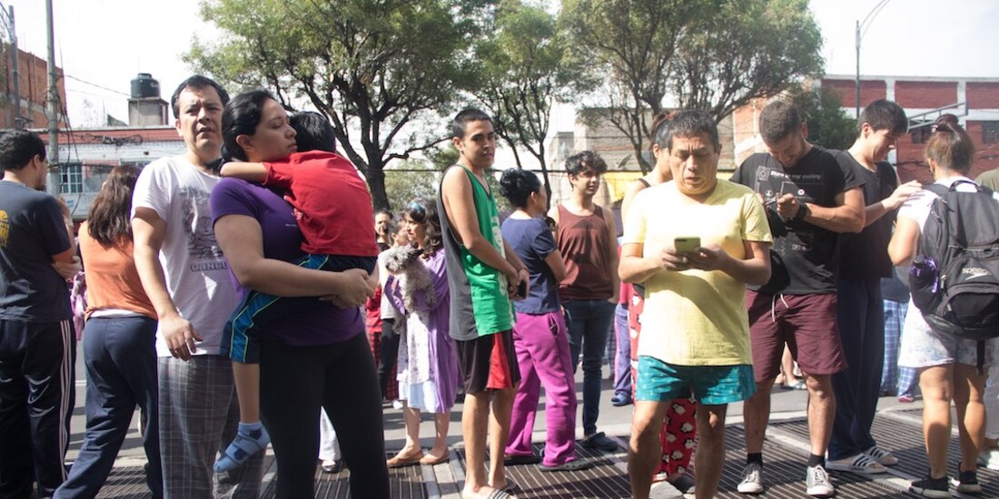 Habitantes de la colonia Santa María la Ribera se agrupan en una banqueta tras el sonido de la alerta sísmica, ayer por la mañana.