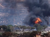LAS LLAMAS se elevan en Líbano, mientras fuerzas israelíes demuelen viviendas, ayer.