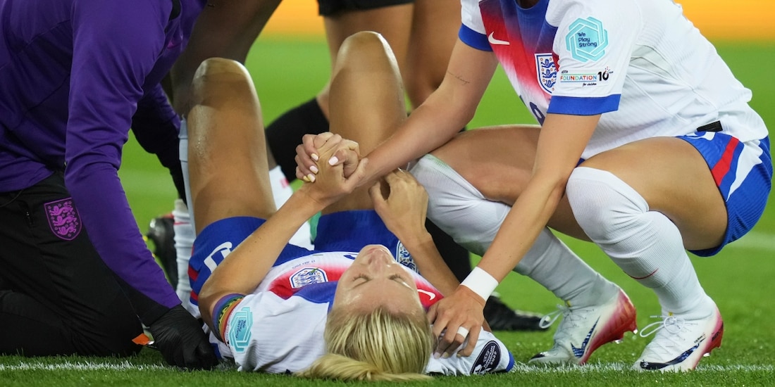 Chloe Kelly sostiene la mano de su compañera Leah Williamson de la selección inglesa tras lesionarse en el encuentro de cuartos de final ante Suecia