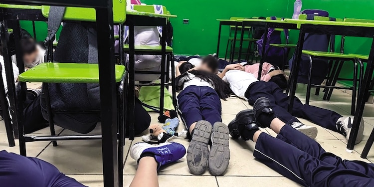 Niños de una primaria en Culiacán se resguardan en el suelo durante una balacera, en diciembre de 2024.