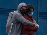 Pareja se abraza previo al semáforo en verde en Eje Central, ambos portan cubrebocas como medida de prevención de contagio del virus COVID-19.