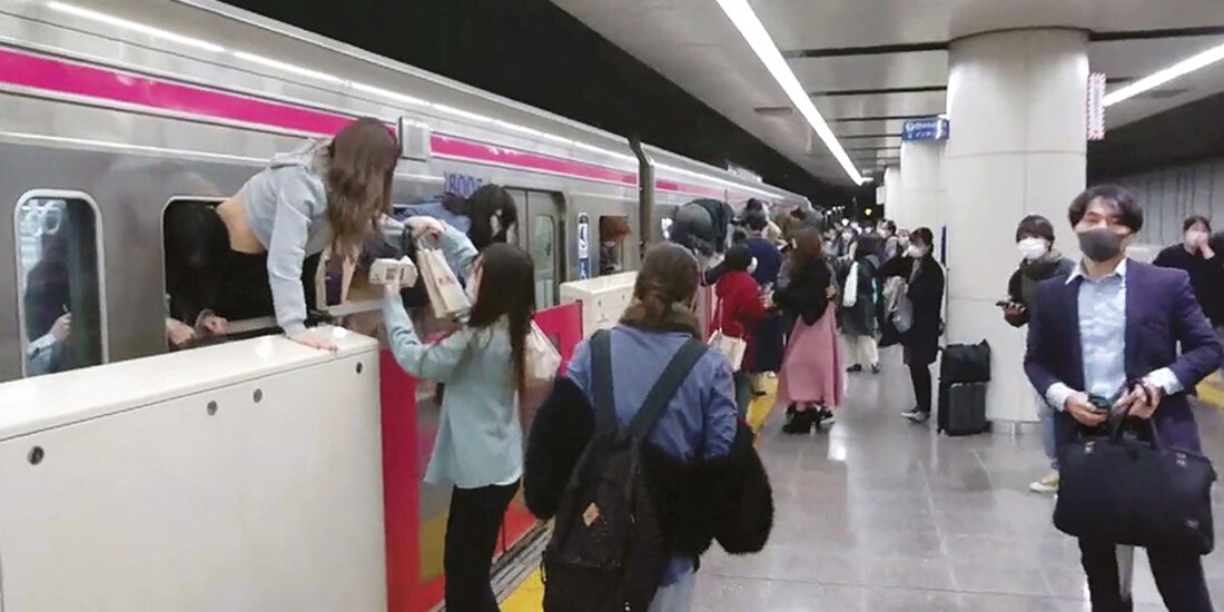 Pasajeros en Kokuryo ayudan a otros a salir por la ventana del tren en el que se encontraba el sospechoso disfrazado, ayer.