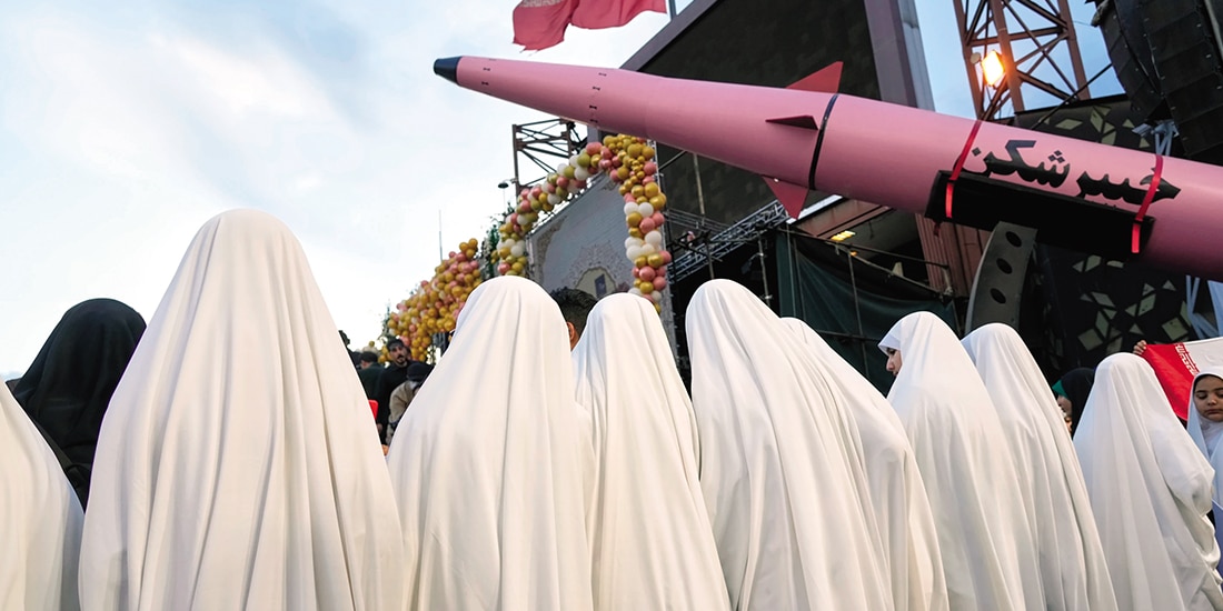 Un grupo de novias iraníes junto a un misil durante una boda colectiva el lunes.