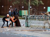 Demonstrators take cover during clashes with security forces during a protest near parliament, as Lebanon marks the one-year anniversary of the explosion in Beirut, Lebanon August 4, 2021. REUTERS/Mohamed Azakir TPX IMAGES OF THE DAY