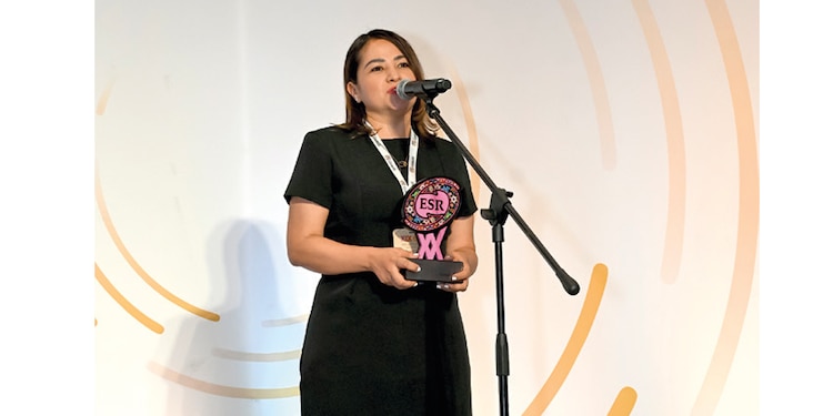Mei Crespo, directora de Asuntos Corporativos, recibe distintivo el martes.