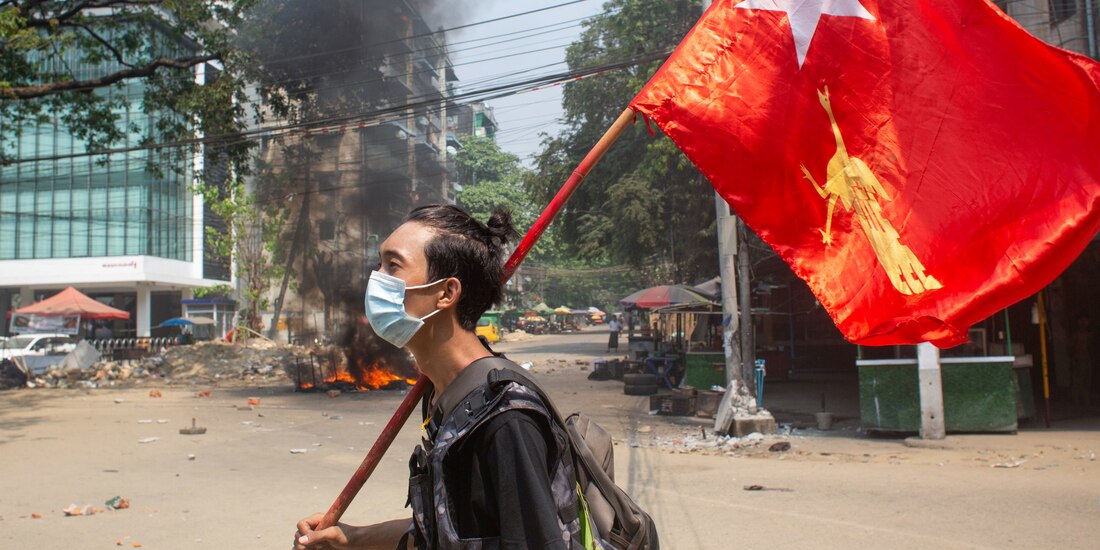 Un manifestante sostiene la bandera de la Liga Nacional de la Democracia, en rechazo al golpe de estado ocurrido en Myanmar.