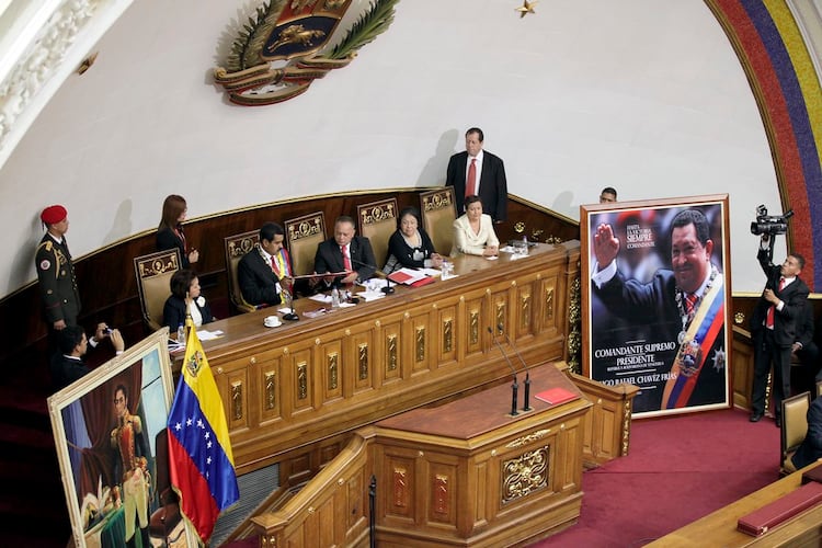 Nicolás Maduro, en su primera juramentación como presidente de Venezuela; al lado, un retrato de Hugo Chávez.