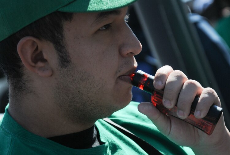 Un hombre fuma un vapeador en una protesta contra su prohibición, en marzo de 2024.