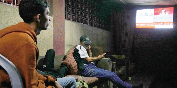 Palestinos siguen el anuncio de Trump por televisión, en Gaza.