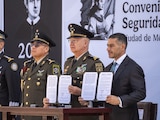 Omar García Harfuch (der.) y Ricardo Trevilla Trejo (izq.) muestran el acuerdo firmado.
