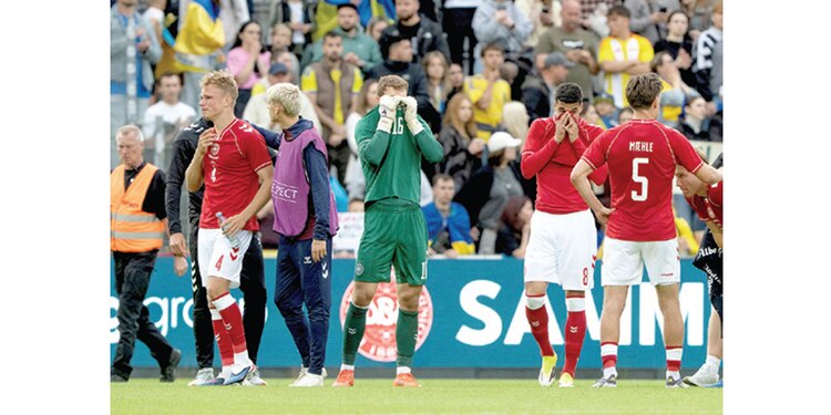 JUGADORES de Dinamarca reaccionan
consternados e incrédulos, momentos después
de que Christian Eriksen se desvaneció
en pleno juego contra Ucrania, ayer.