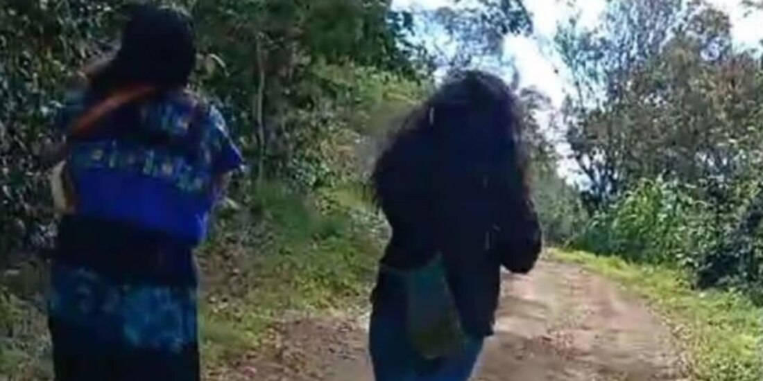 Dos mujeres caminan por la comunidad de Los Chorros tras la trifulca, ayer.